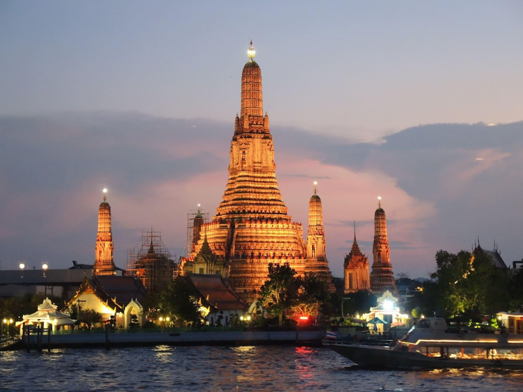 Sonnenuntergangsstimmung mit Blick auf den erleuchteten Wat Arun in Bangkok