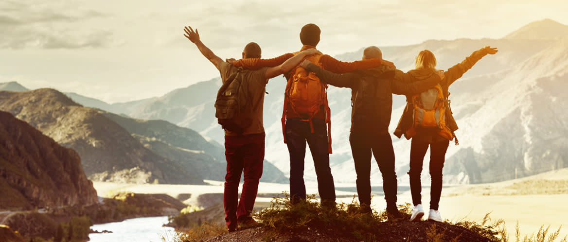 Four hikers celebrate reaching a mountain peak