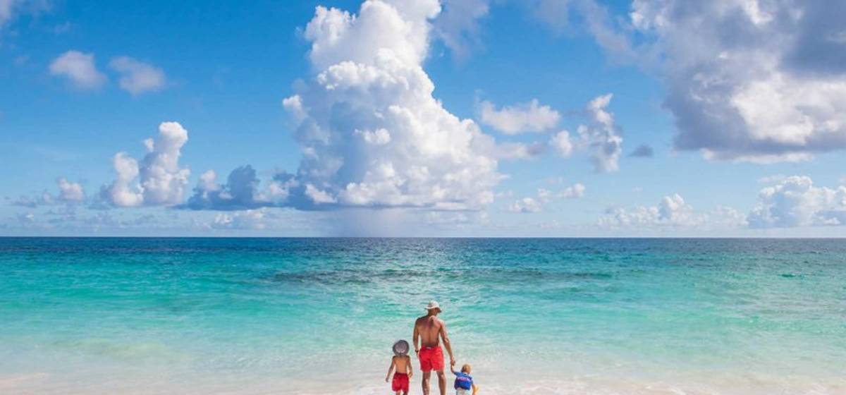 Father and sons walking on beach