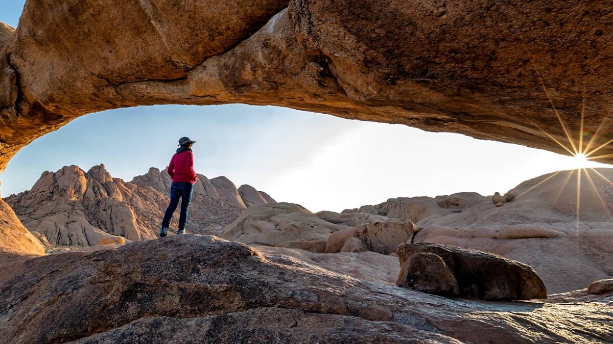 Enchanting Travels Namibia Tours Nature reserve Spitzkoppe in Namibia. Picturesque stone arches are painted by iron oxides in red-orange