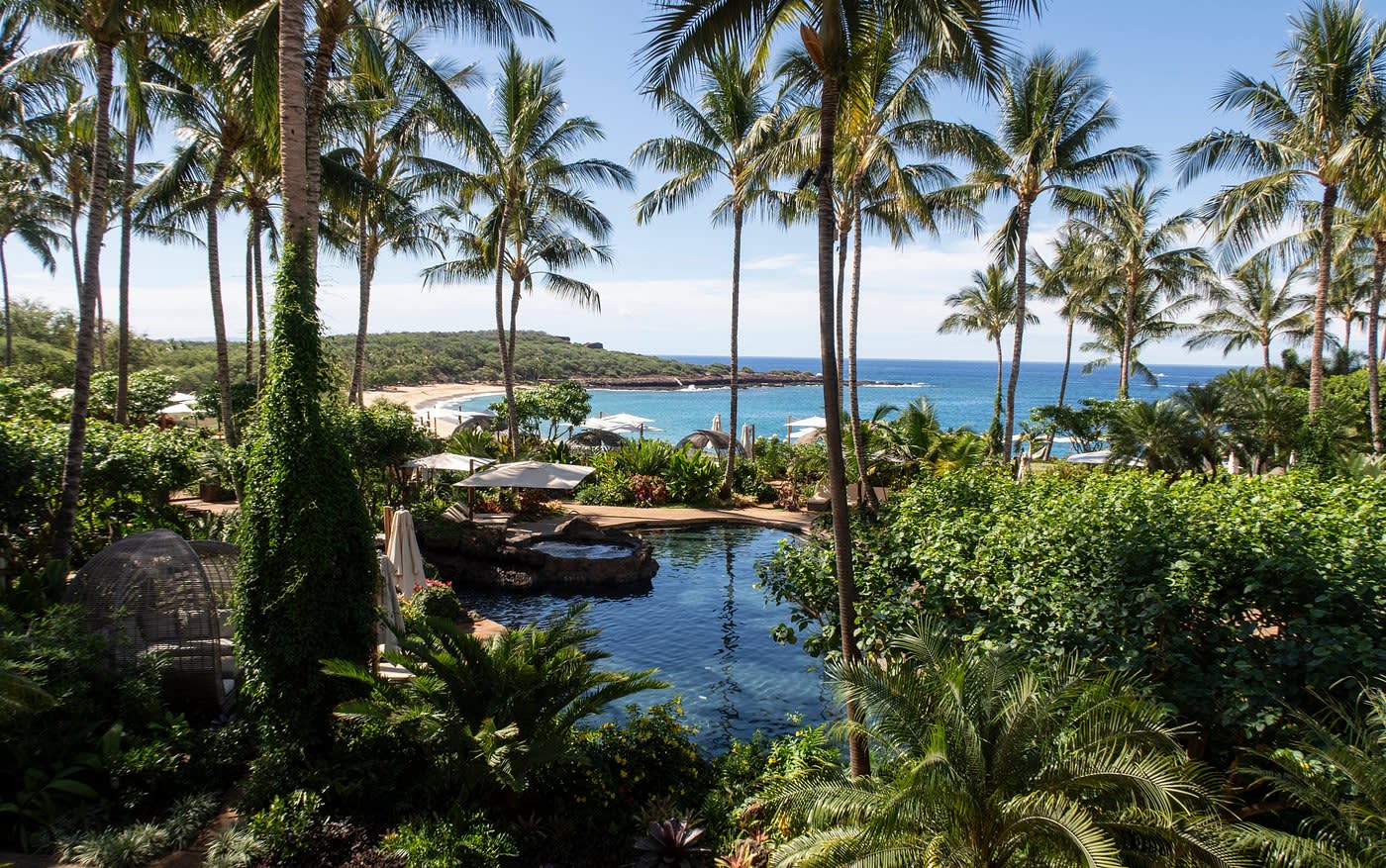 Tropische palmengesäumte Poollandschaft des Four Season Resort Lanai mit Strand im Hintergrund