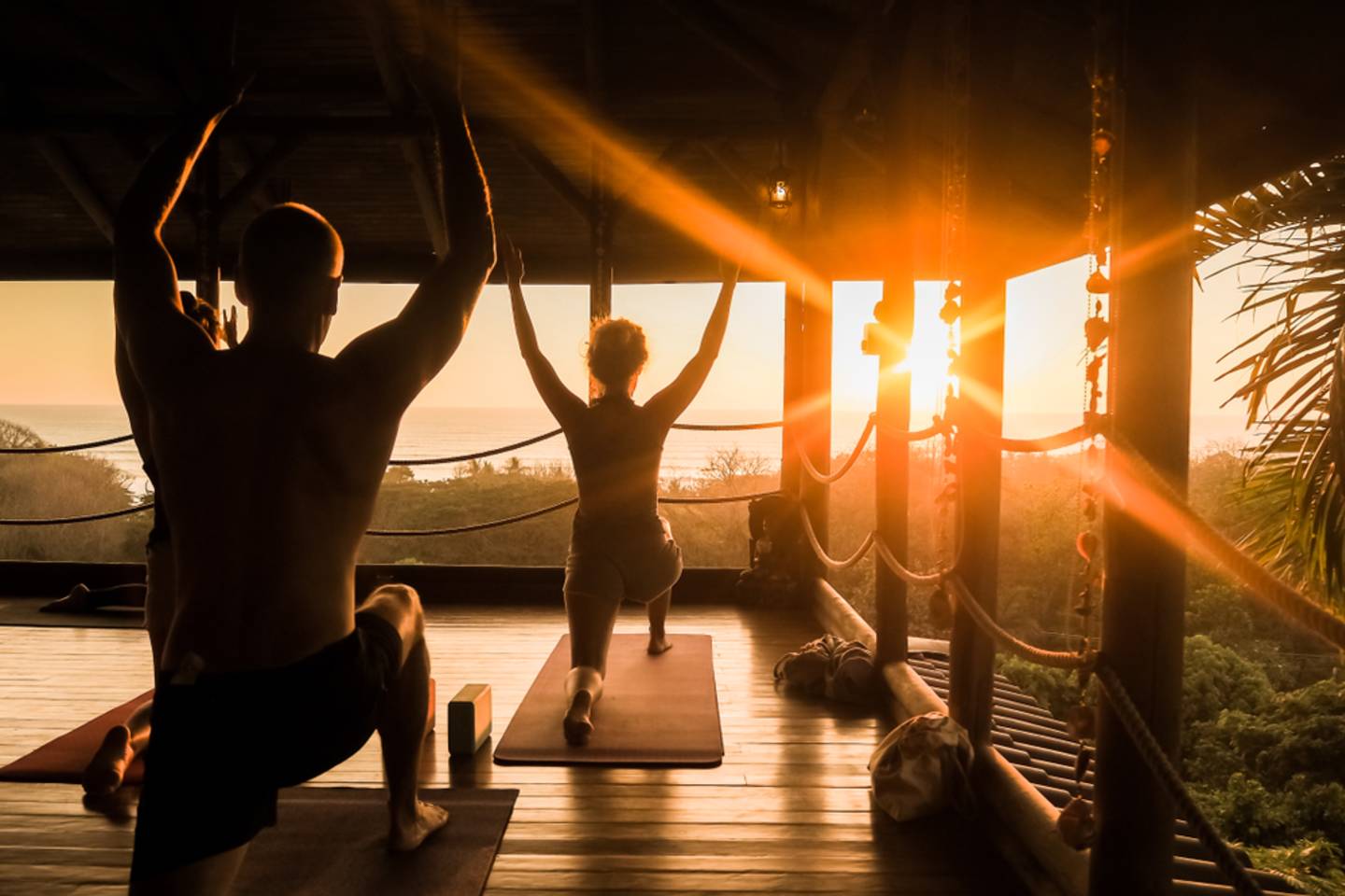 two people doing yoga at sunset