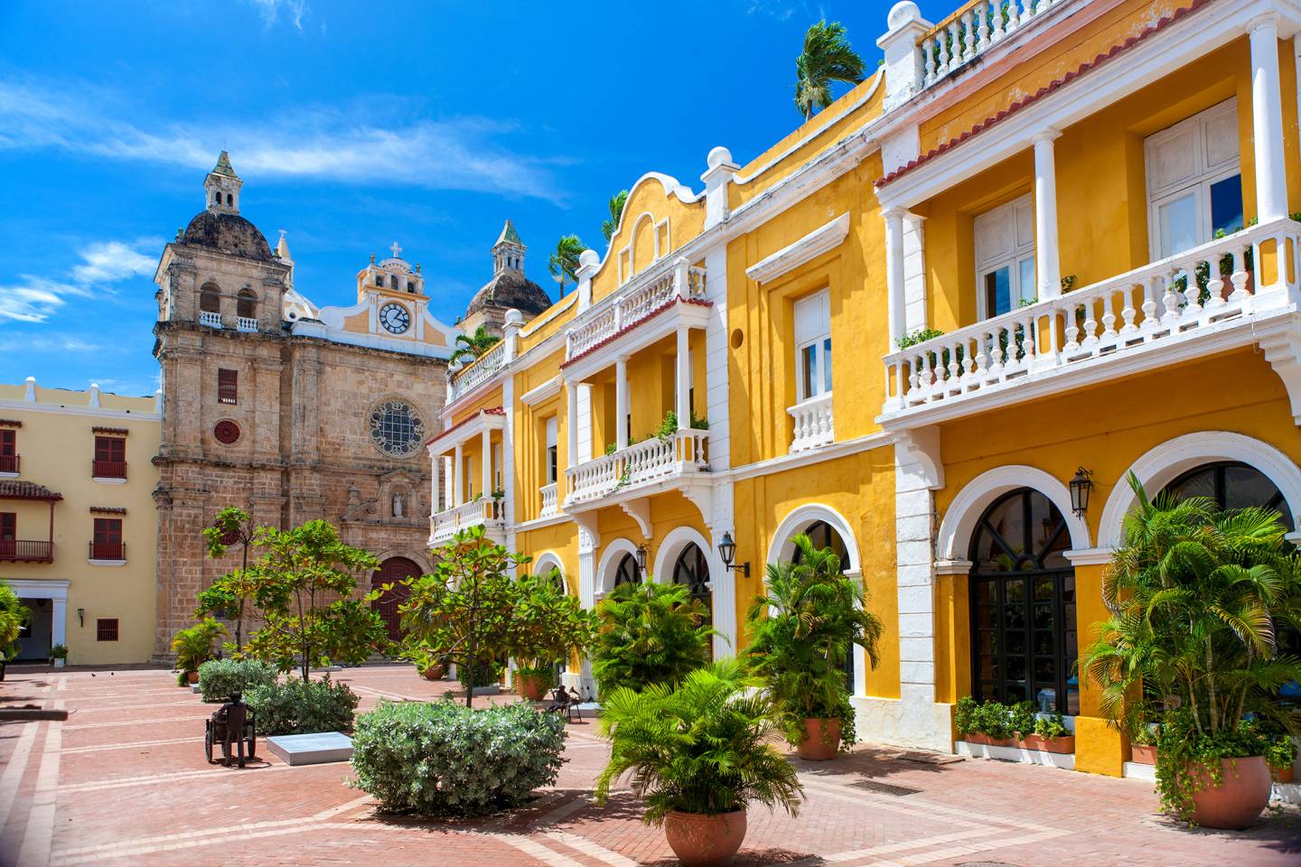 yellow building and church by city square