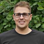 a man wearing glasses and smiling at the camera