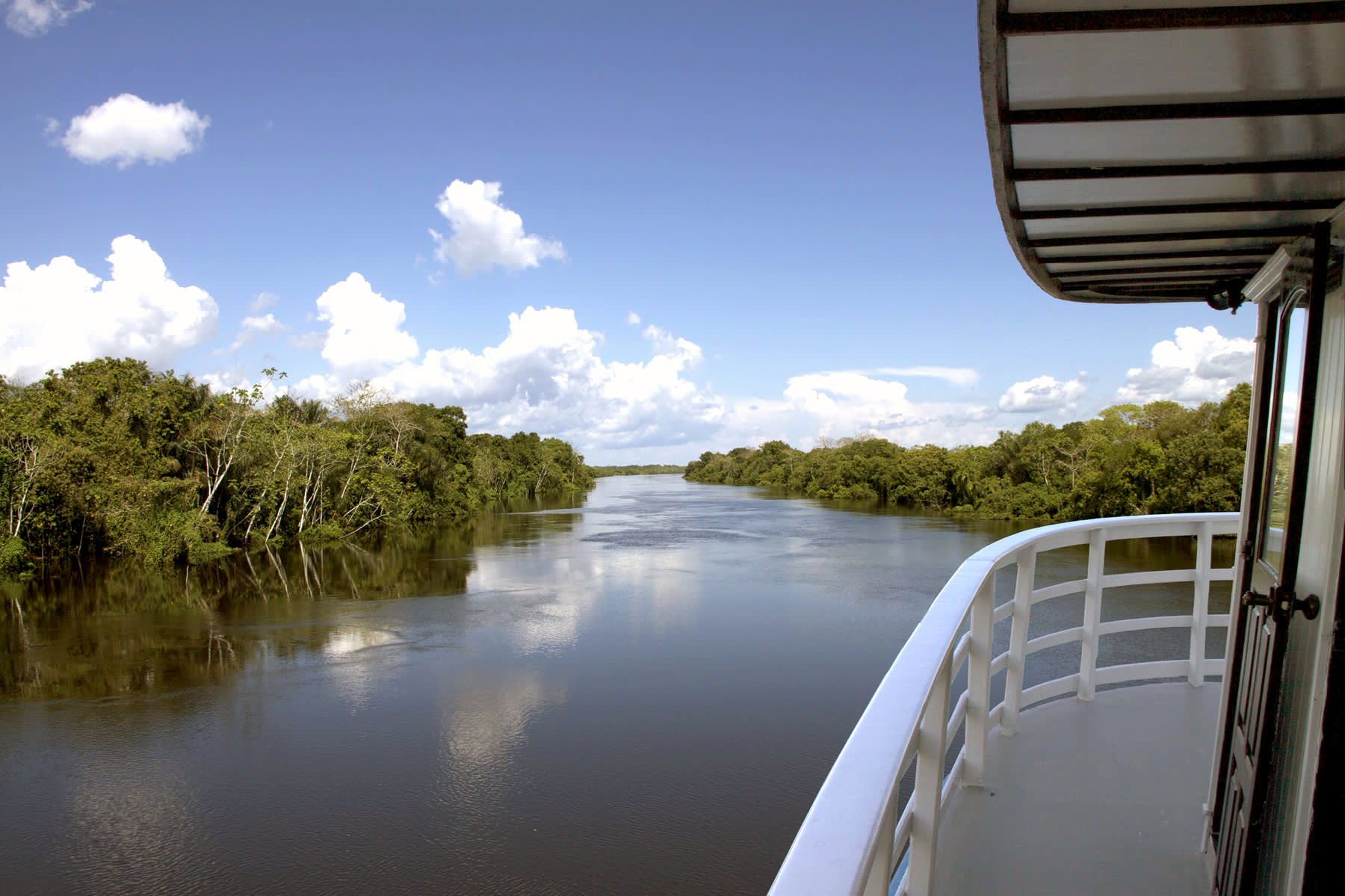 Blick von der Motorjacht auf einen, links und rechts von Dschungel gesäumten, Nebenfluss des Amazonas in Brasilien