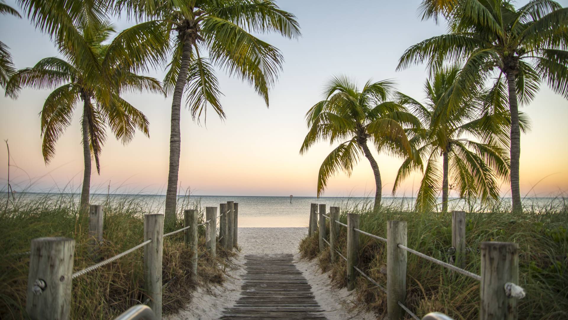 Key West Florida - Famous passage to the beach with palms, sunset and view on the ocean.