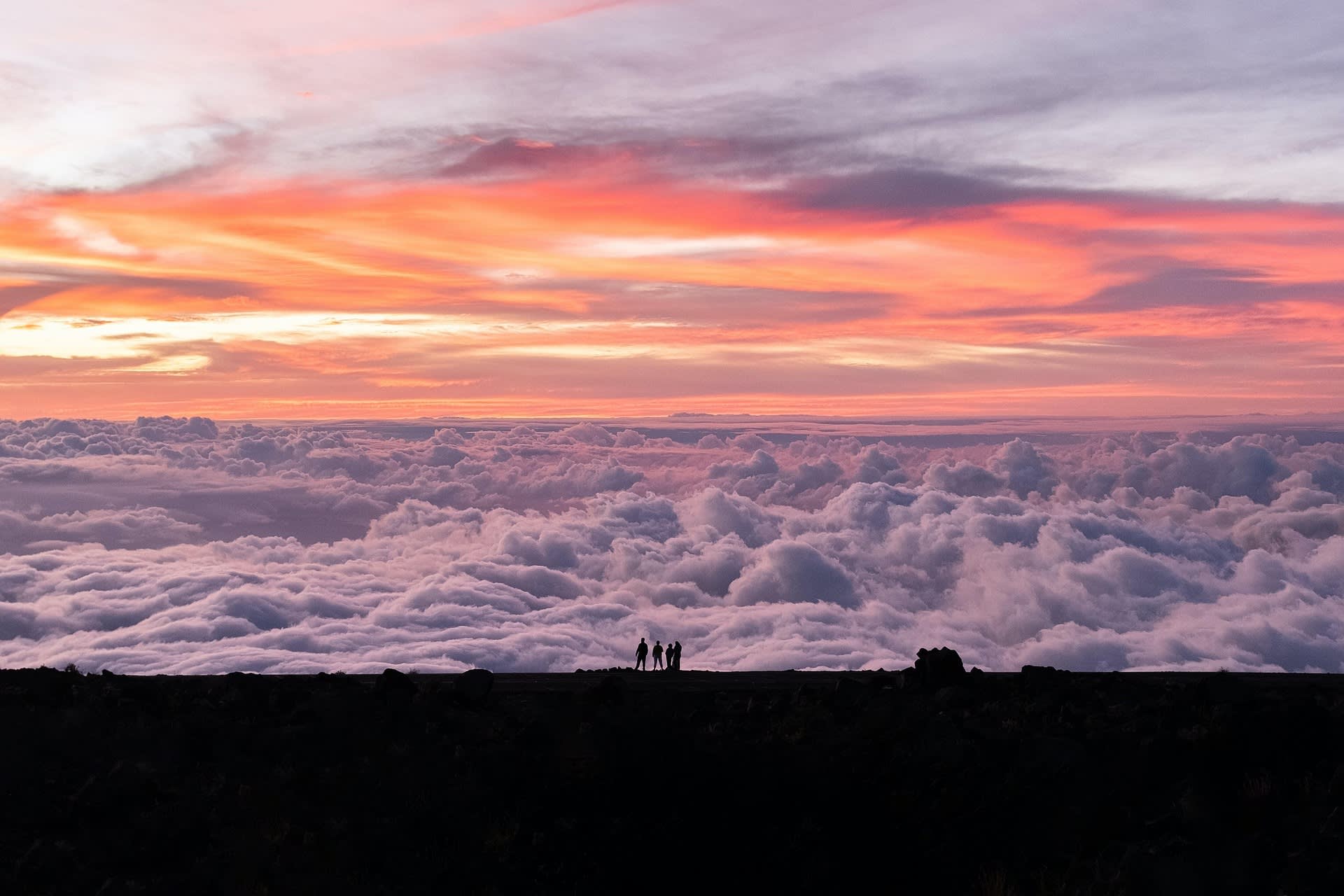 Von der aufgehende Sonne in Pastellfarben getauchter Himmel über der Wolkendecke des Haleakala, Maui.