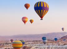 Hot air balloon flying over rock landscape at Cappadocia, Turkey