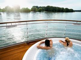 A couple enjoying the scenic view from the pool aboard the cruise
