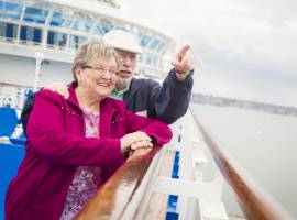 Happy senior couple enjoying the view from deck of the cruise ship