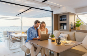 Couple on laptop on a catamaran