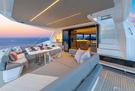 Moorings 534PC flybridge with a dining table, settee seating, a grill, and companionway leading to the saloon and galley below.