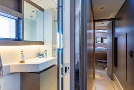 Head with vanity unit and mirror aboard a Moorings 534PC, with a cabin berth visible through the open doorway.