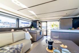 Moorings 534PC saloon and galley with a settee, saloon table and cooktop.