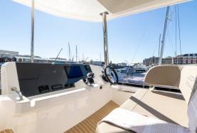 Moorings 534PC flybridge helm with chartplotter, multifunction displays, and helm seat under a bimini.