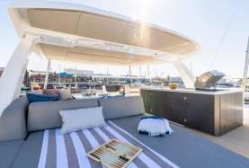Moorings 534PC flybridge with a settee, an outdoor galley unit, and an open grill.