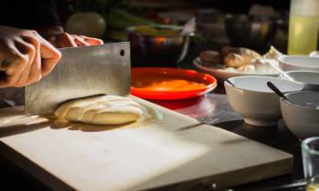 a person preparing food in a bowl on a table