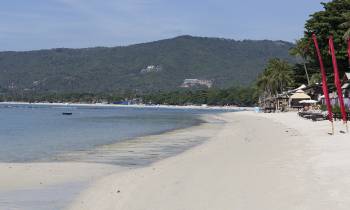 a sandy beach next to a body of water