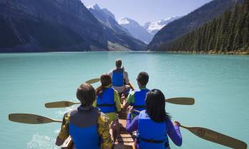 a group of people sitting in a boat on a body of water