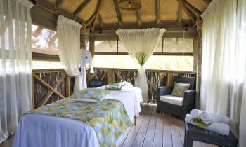 a bedroom with a bed and a chair in a room