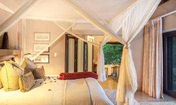 a bedroom with a bed and a chair in a room
