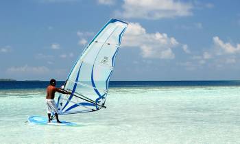 a man flying a kite in a boat on a body of water
