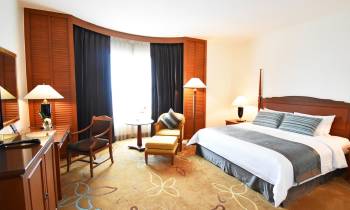a bedroom with a bed and desk in a hotel room