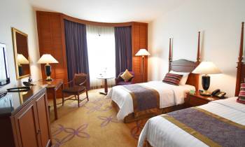 a bedroom with a bed and desk in a hotel room
