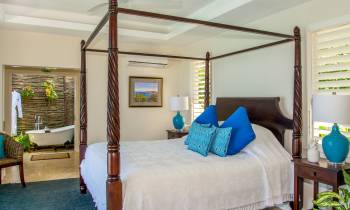 a bedroom with a bed and a chair in a room
