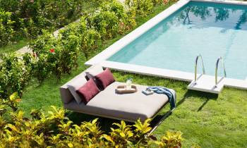 a couple of lawn chairs sitting on top of a grass covered field