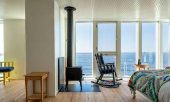 a bedroom with a bed and a chair in a room