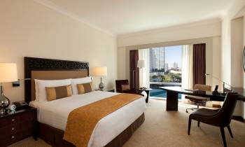 a bedroom with a bed and desk in a hotel room