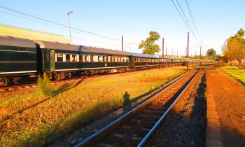 a yellow train is coming down the railroad tracks