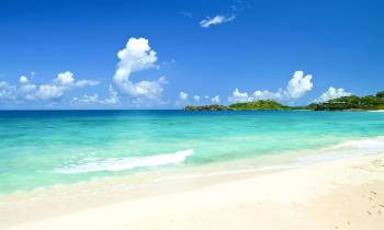 a sandy beach next to the ocean