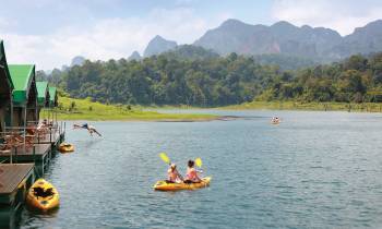 a small boat in a body of water with Li River in the background