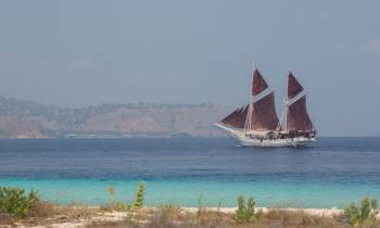 a boat on a body of water with a mountain in the background