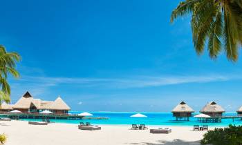 a group of lawn chairs sitting on top of a sandy beach