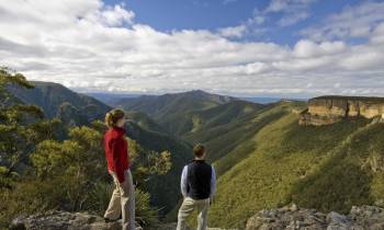 a man and a woman standing in front of a mountain