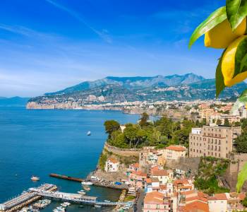 Aerial view of cliff coastline Sorrento and Gulf of Naples, Italy. Ripe yellow lemons in foreground. In Sorrento lemons are used in production of limoncello.