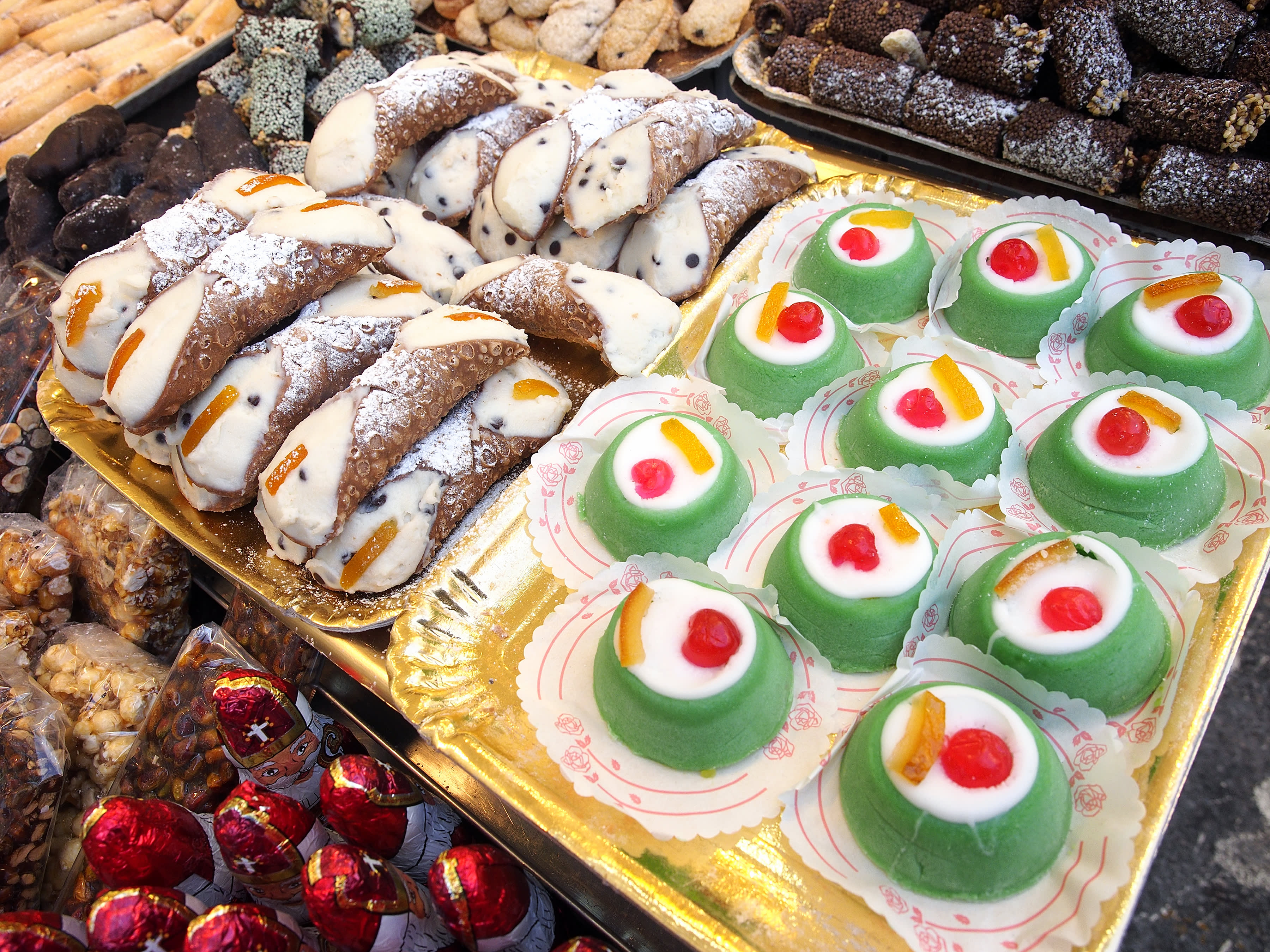 Sicilian food: cannoli and cassate on sale in a street food market.