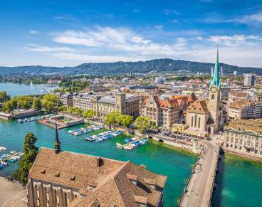 Aerial view of historic Zurich city center with famous Fraumunster Church and river Limmat at Lake Zurich from Grossmunster Church on a sunny day with clouds in summer, Canton of Zurich, Switzerland