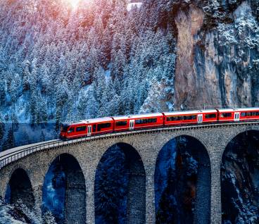 Aerial view of Train passing through famous mountain in Filisur, Switzerland. train express in Swiss Alps snow winter scenery.