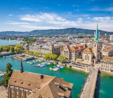 Aerial view of historic Zurich city center with famous Fraumunster Church and river Limmat at Lake Zurich from Grossmunster Church on a sunny day with clouds in summer, Canton of Zurich, Switzerland