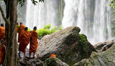 Group of young buddhist monks enjoying the view of Kulen Waterfall in Cambodia, Asia