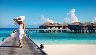 Asian couple enjoying romantic luxury lunch setting at tropical beach in Maldives
