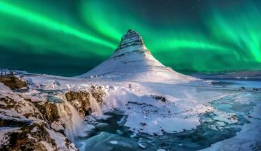 northern lights appear over Mount Kirkjufell in Iceland.