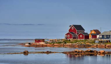 Aufnahme mehrerer roter Holzhäuser an einer Bucht auf Fogo Island, Neufundland und Labrador, Kanada