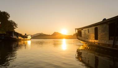 Traditionelle Holzboote auf dem Mekong bei Sonnenuntergang Luang Prabang, Laos