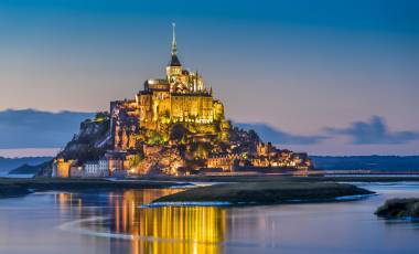 Beautiful view of famous Le Mont Saint-Michel tidal island in beautiful twilight during blue hour at dusk, Normandy, northern France