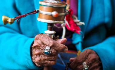 Buddhistische Gebetsmühle in der Hand einer älteren Frau, Nepal
